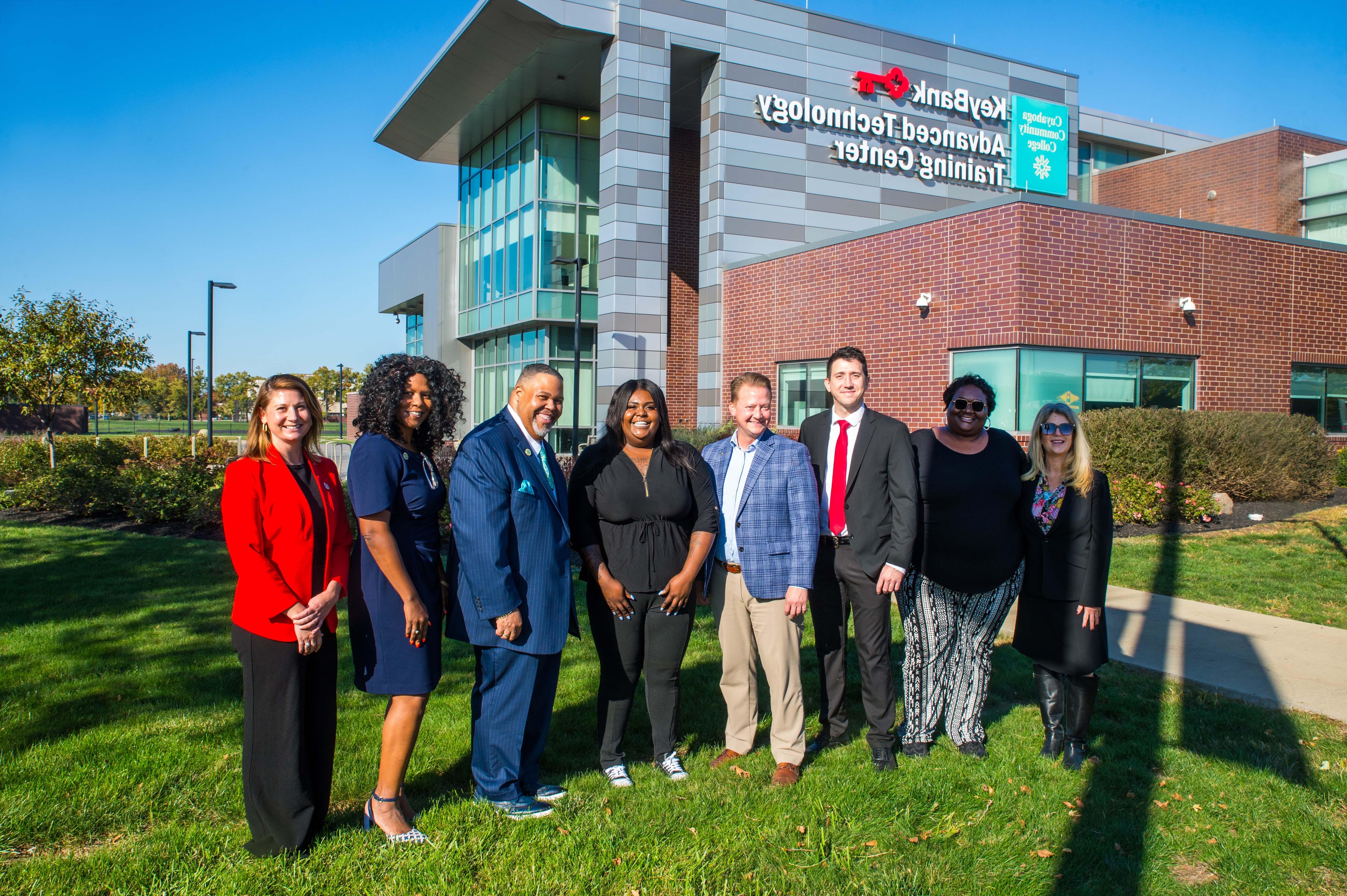 Leadership from KeyBank, Tri-C and Tri-C Foundation in a line standing in front of the KeyBank Advanced Technology Training Center, signage clearly visible. Sunny Fall day.